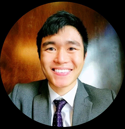 Bartholomew Zhang standing in front of a wooden background